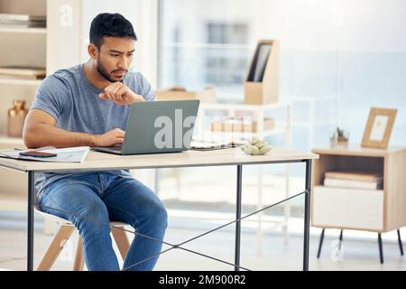 Focused on the end goal. a young businessman using a laptop in an office at work. Stock Photo