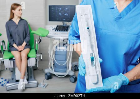 doctor gynecologist offers female patient to use IUD to prevent pregnancy. Intrauterine contraceptive device or coil Stock Photo