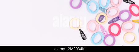 Banner with many multicolored hair scrunchies and clips on a blue background. Place for text.