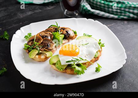 Sandwiches  with avocado, fried egg and mushrooms  for healthy breakfast or snack. Stock Photo