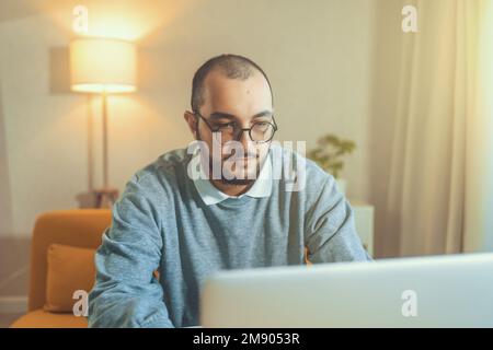 Male freelancer or IT code developer working at laptop. Programmer or young businessman at home office, distant job. Stock Photo