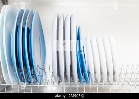 Dish drying metal rack with big nice white clean kitchenware. Traditional  wall cabinet kitchen Stock Photo by Vladdeep