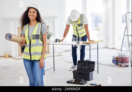 Were doing what we do best. an attractive young contractor standing inside and holding building plans. Stock Photo
