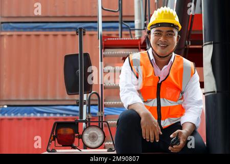 asia man worker sitting on the stairs for resting and take a break after finish work in the cargo at the port or warehouse factory. Industry and logis Stock Photo