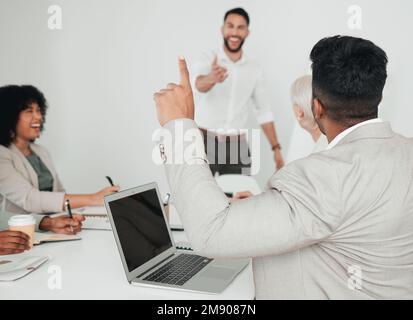 All your questions will be answered. a businessman raising his hand to ask a question in a meeting at work. Stock Photo