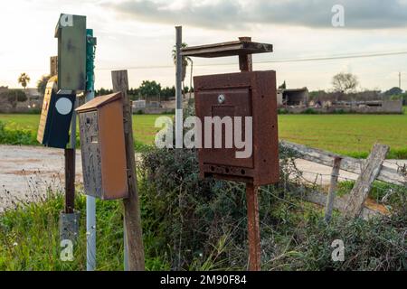 Close-up of old and dilapidated mailboxes in a rural area on the island of Mallorca, Spain. Conceptual image of the abandonment of rural people Stock Photo