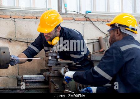 Engineer man training with foreman for apprentice using lathe, apprenticeship teaching with worker, technician and learning, inspector and labor, inte Stock Photo