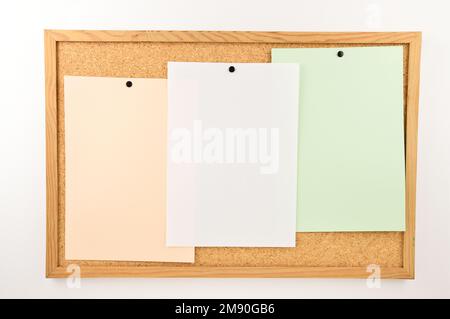 close up of thumbtack and three notes on billboard Stock Photo