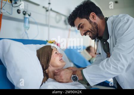 Young middle eastern doctor smiling during examining patients in hospital room. Stock Photo