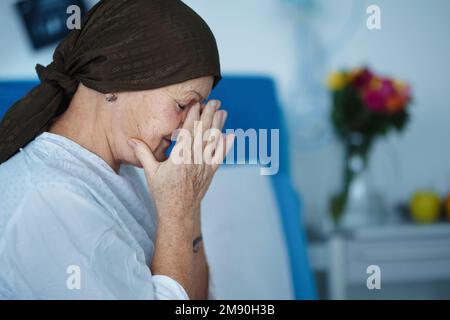 Senior woman sitting in hospital room after chemotherapy. Stock Photo