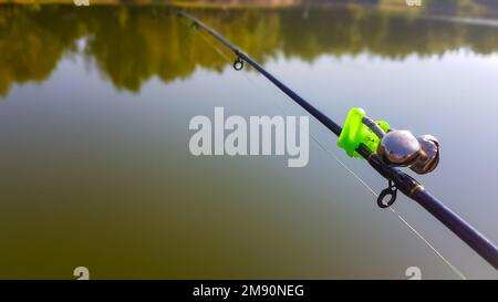Swing fishing. Rods for carp fishing with a signaling close-up. Kind of pod. Fishing for carp on the background of the lake. The fisherman catches Stock Photo