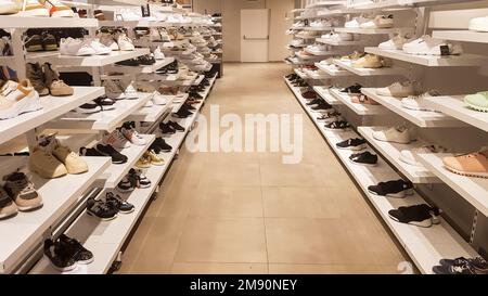 Large collection of different shoes. Shop for men's, women's and children's shoes. Background with shoes on the shelves inside the store. Very large Stock Photo