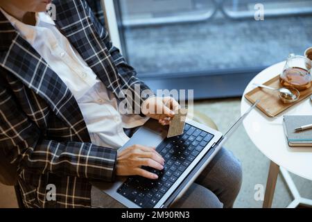 Asian woman enter credit card number on laptop for shopping online ...