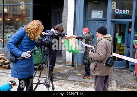 Hastings, East Sussex, 16 January 2023. Heavy rain and blocked storm drain to the sea causes major flood in Hastings Town Centre, closing Priory Meadow shopping centre and flooding homes and businesses. Agi from Subway sandwich shop gives away bread to passers-by. Carolyn Clarke/Alamy Live News Stock Photo