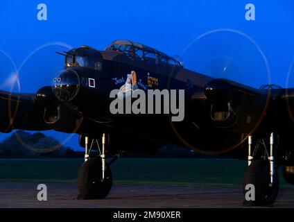 AVRO Lancaster bomber 'Just Jane', under restoration at Lincolnshire Aviation Heritage Centre demonstrating engine run as light fades. Stock Photo