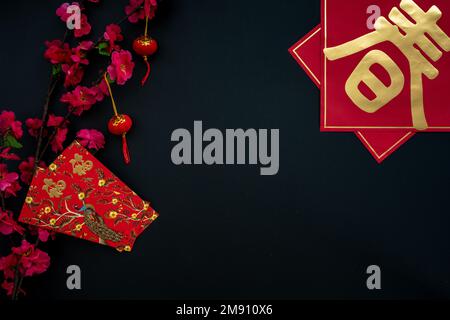 Chinese lunar new year decoration over black background. Flat lay concept with red envelope and festive decoration. Stock Photo
