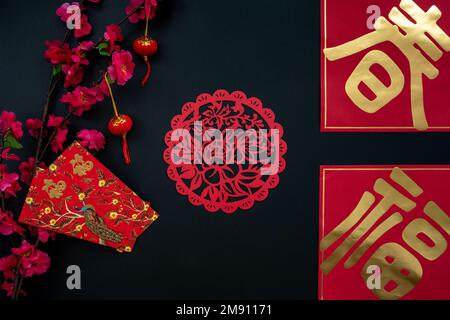 Chinese lunar new year decoration over black background. Flat lay concept with red envelope and festive decoration. Stock Photo