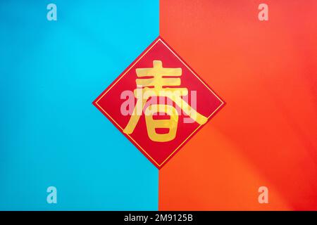 Elegant spring festival flat lay with red and blue background. Chinese text translation: Spring Stock Photo