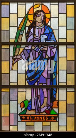 TASCH, SWITZERLAND - JULY 2, 2022: The stained glass with the St. Agnes in the parish church designed by August Wanner and made by Wilhelm Klotz Stock Photo