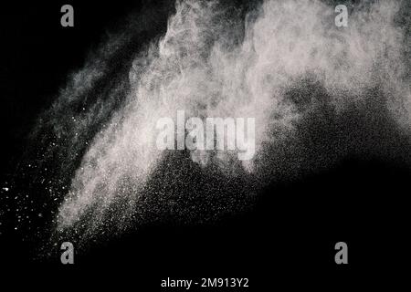 A grayscale of some brown particles exploding on black background, brown dust splashing Stock Photo