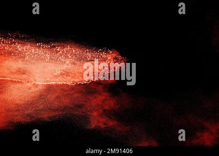 Some brown particles exploding on black background, brown dust splashing Stock Photo