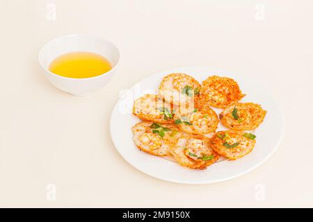 Banh khot Vung Tau, Vietnamese mini savory pancakes with with rice batter and shrimp, vietnamese food isolated on white background, perspective view Stock Photo