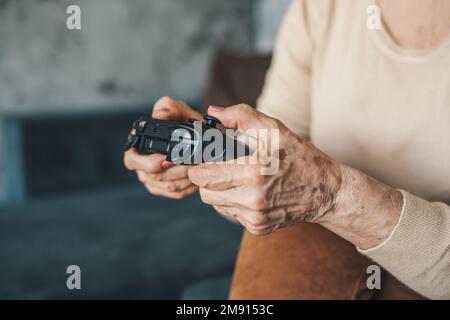Senior woman's hands at home retirement concept sitting playing video games excited, close-up. Activity relationship. Happy lifestyle. Stock Photo