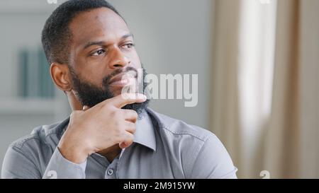 Close up thoughtful pensive ethnic bearded African American man thinking businessman worker searching solution boss think ponder idea business Stock Photo