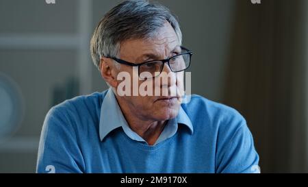 Close up old thoughtful pensive confused senior man feel worried think memory problem forgotten information, elderly old teacher look away anxious Stock Photo