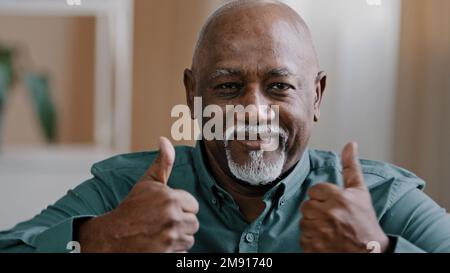 Portrait of happy elderly african american man smiling old senior putting two thumbs up positive grandfather looking at camera showing hand gesture of Stock Photo