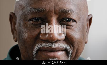 Close up African American male face with wrinkles and gray beard cheerful happy biracial smiling bald man looking at camera smile toothy dentistry Stock Photo