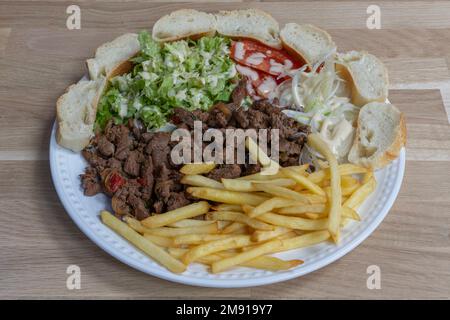 Bistro dishe culinary Still Life. Flank Steak with salad, tomato accompaniement onion, french fries and slice of bread Stock Photo