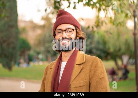 Portrait of a young adult man smiling looking at camera. Hipster man with glasses and beard. Stock Photo