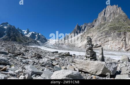 The glacial stream on the glacier Mer de Glace with the Garand Jorasses and Aigulles towers in the background. Stock Photo