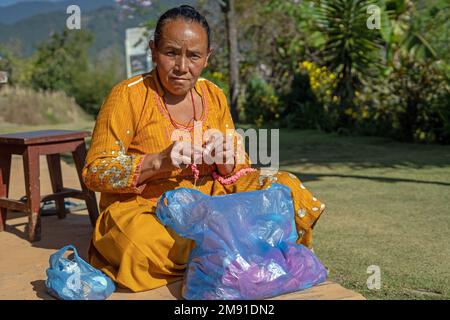 Dolakha District, Nepal - December 2022 -  Nepal Woman at home  in the backyard knotting  wool ornament Stock Photo
