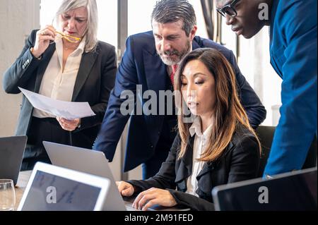 Group fo business people working together on financial trading and stock market, focus on mature japanese businesswoman Stock Photo
