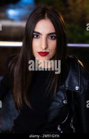 A vertical shot of a stylish woman wearing a leather jacket outdoors Stock Photo