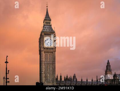 London, UK. 16th Jan, 2023. Dark clouds are illuminated in soft pink and orange by the setting sun at Big Ben and the Houses of Parliament in London, following a mostly dry, but bitterly cold afternoon in Westminster. Temperatures are forecast to drop further with potential rain and even snowfall in the next few day. Credit: Imageplotter/Alamy Live News Stock Photo