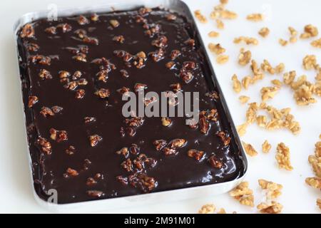 Texas Sheet Cake in baking pan. It is a large, thin chocolate cake topped with a rich chocolate walnut frosting. It's moist and fluffy, with a hint of Stock Photo