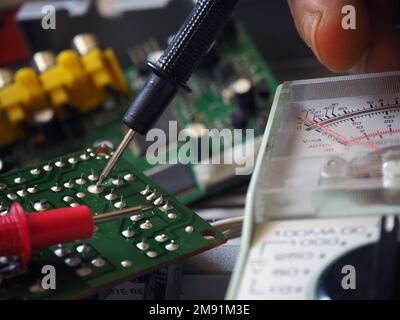 Electronic circuit board testing or troubleshooting with a multimeter. Electronics industry background. Stock Photo