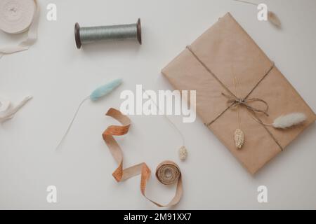 minimal mockup with blank frame with sewing thread and sewing items on white background, flatlay, top view, copy space Stock Photo