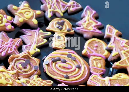 Colorful decorated gingerbread cookies on a black plate Stock Photo