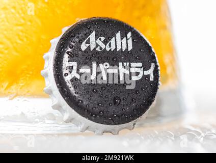 LONDON, UK - DECEMBER 22, 2022: Asahi super dry beer bottle cap with dew and cold glass on white. Stock Photo