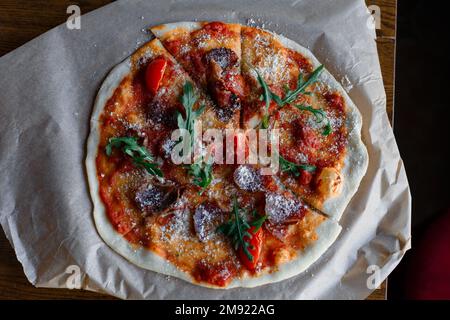 Spicy pizza with sausages and chili peppers. On a black stone background. Free space for text. High quality photo Stock Photo