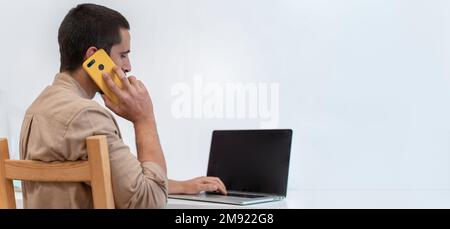 Young graphic designer sitting at his work desk and using a color palette to do an art project Stock Photo