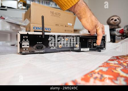 Paris, France - Dec 13, 2022: POV male hand pointing to DAB radio antenna conneciton on new Onkyo NS-6170 network audio player with DSD Hi-Res Audio and DSD DAB WIFI device after unboxing Stock Photo