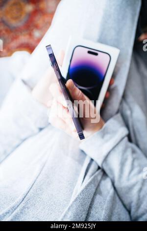 London, United Kingdom - Sep 28, 2022: POV woman hand ide of surgial grade stainless-steel newly released iPhone 14 pro by Apple Computers with always-on display and dinamyc island Stock Photo