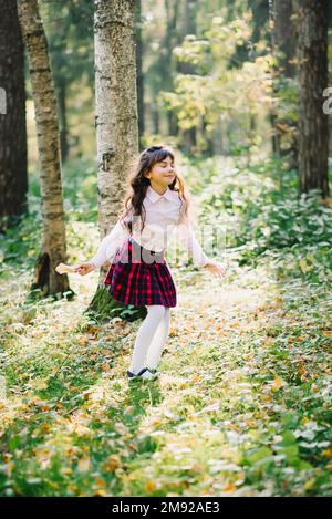 happy beautiful brunette girl is spinning and enjoying herself in the Park in autumn Stock Photo