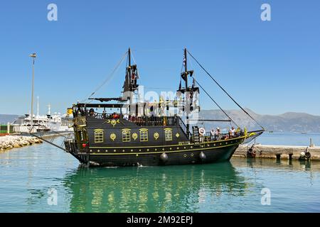 Corfu, Greece - June 2022: Boat in the shape of a pirate ship with tourists on board in the town's harbour. Stock Photo