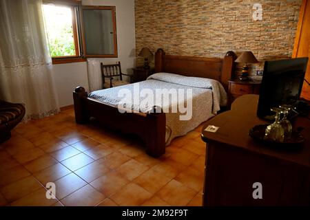 Double bed in a comfortable bedroom with window, tiled floor, wood furniture in hotel Casa Elisa Canarias, Fatage, Gran Canaria Stock Photo